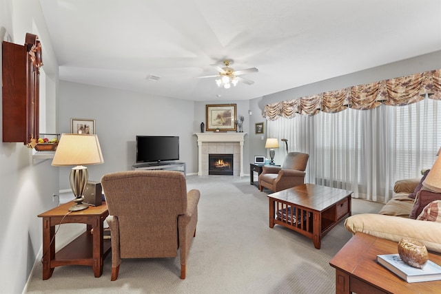 living room featuring light carpet, a tile fireplace, and ceiling fan