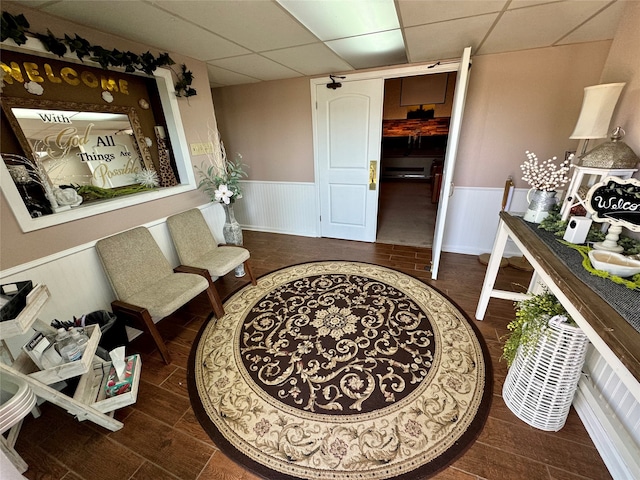 sitting room featuring a paneled ceiling and dark hardwood / wood-style flooring