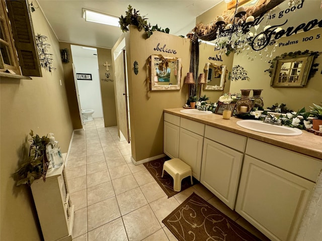 bathroom with tile patterned flooring, vanity, and toilet