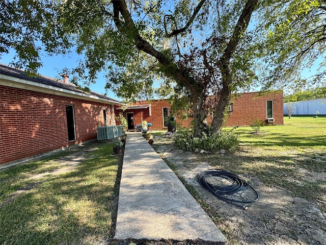 view of front of property with central AC unit and a front lawn