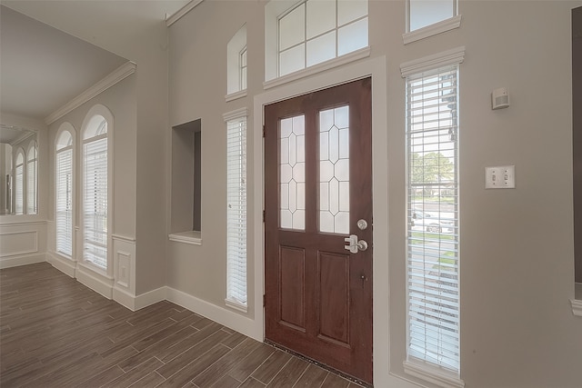 foyer entrance featuring dark wood-type flooring and crown molding