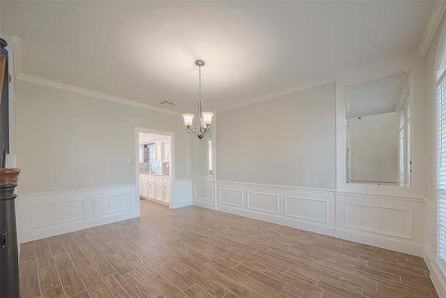 spare room with sink, light hardwood / wood-style flooring, crown molding, and a chandelier