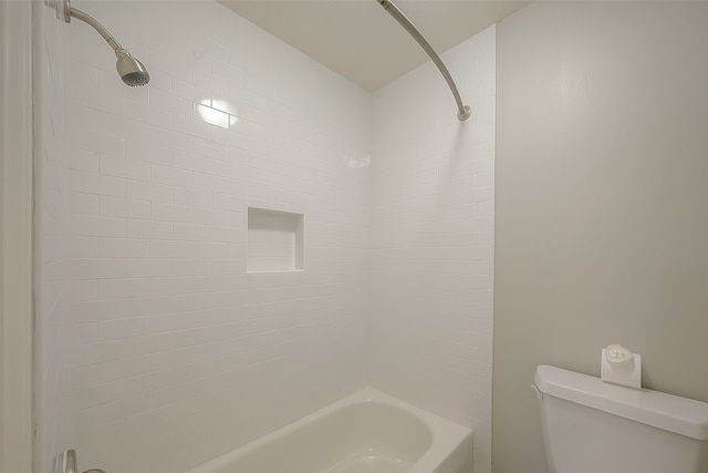 bathroom featuring tiled shower / bath and toilet