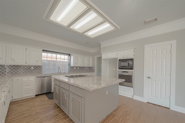 kitchen with black appliances, a kitchen island, and white cabinetry