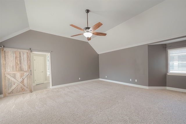 bonus room featuring a barn door, light colored carpet, vaulted ceiling, and ceiling fan