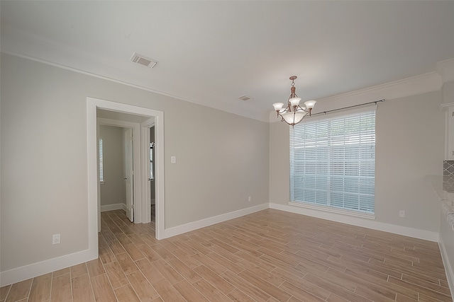 empty room featuring an inviting chandelier, light hardwood / wood-style flooring, and crown molding