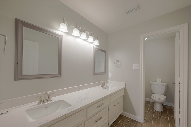 bathroom featuring wood-type flooring, vanity, and toilet