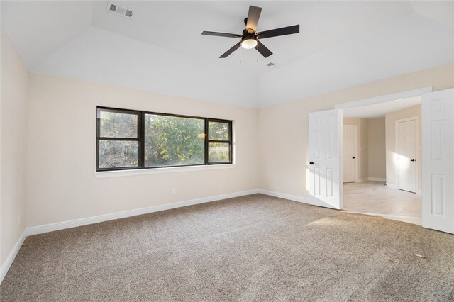 carpeted spare room featuring ceiling fan and vaulted ceiling