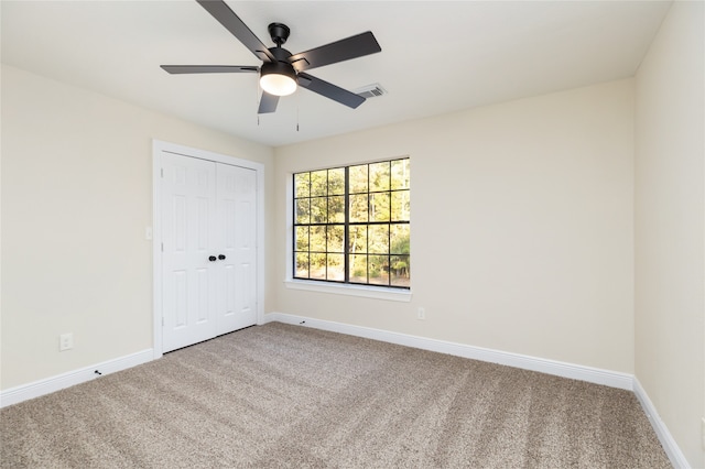 carpeted spare room with ceiling fan