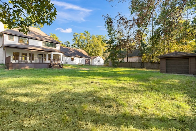 view of yard featuring a garage, an outbuilding, and a porch