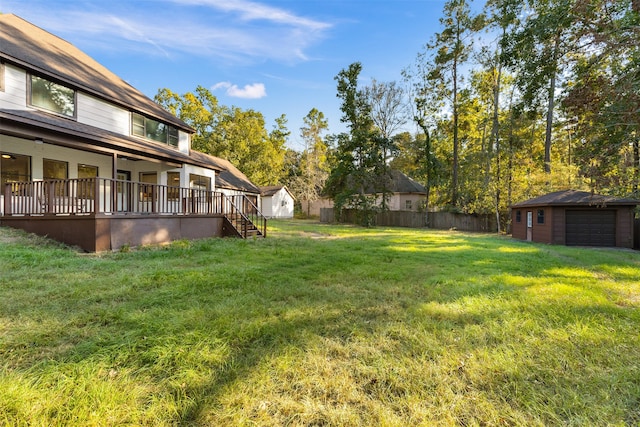 view of yard featuring a deck, an outbuilding, and a garage