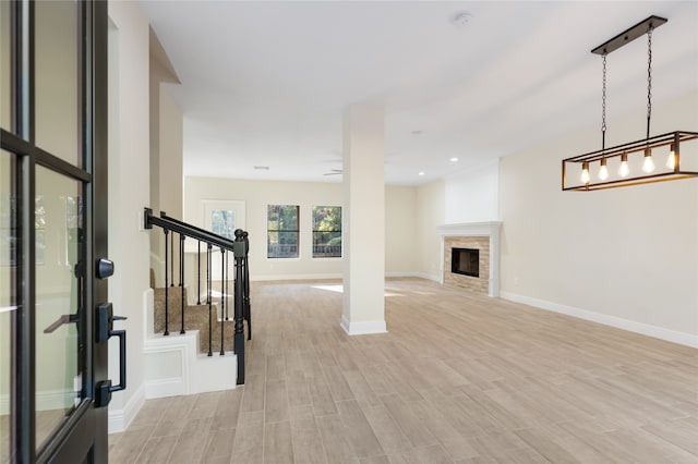 interior space with a stone fireplace and light hardwood / wood-style floors