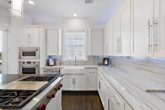 kitchen with white cabinets, crown molding, sink, and decorative backsplash