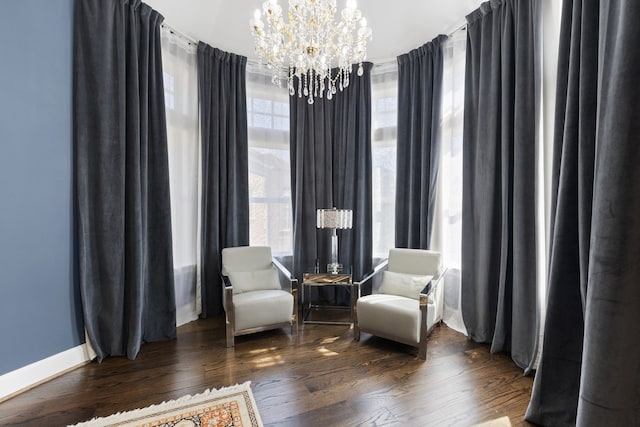 living area with a notable chandelier and dark hardwood / wood-style flooring