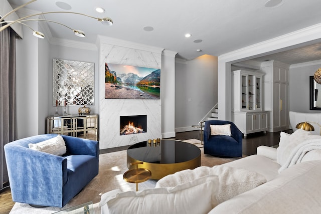 living room with hardwood / wood-style flooring, crown molding, and a high end fireplace