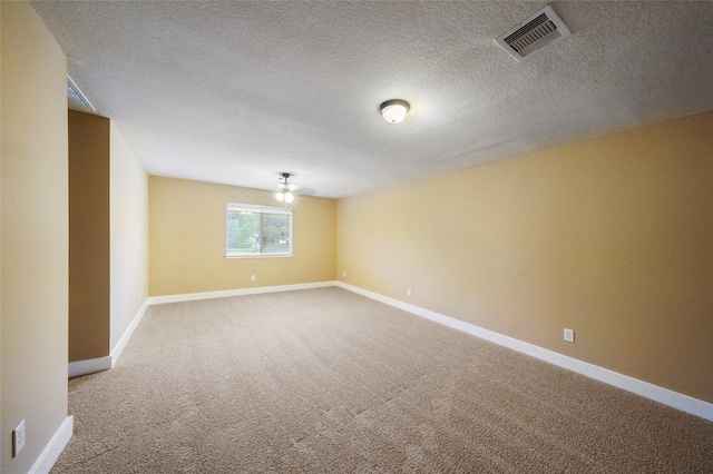 empty room featuring a textured ceiling and carpet flooring