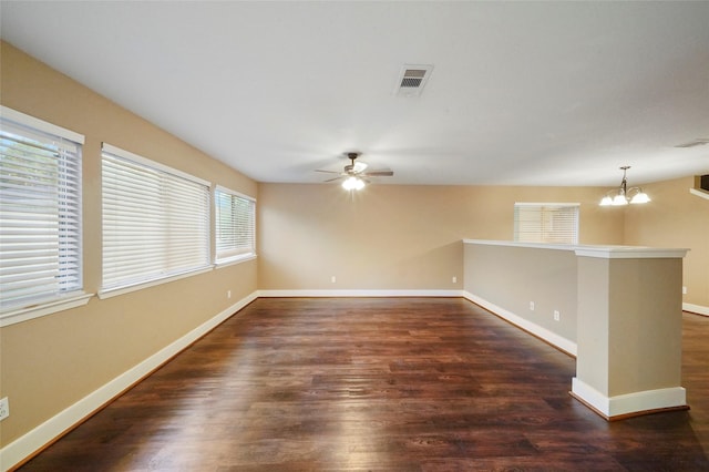 unfurnished room featuring dark hardwood / wood-style floors and ceiling fan with notable chandelier