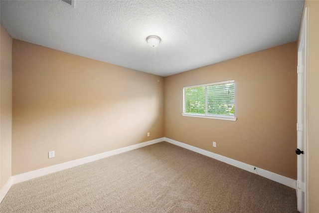 unfurnished room with a textured ceiling and carpet flooring