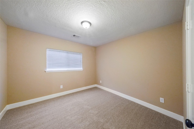 carpeted empty room featuring a textured ceiling