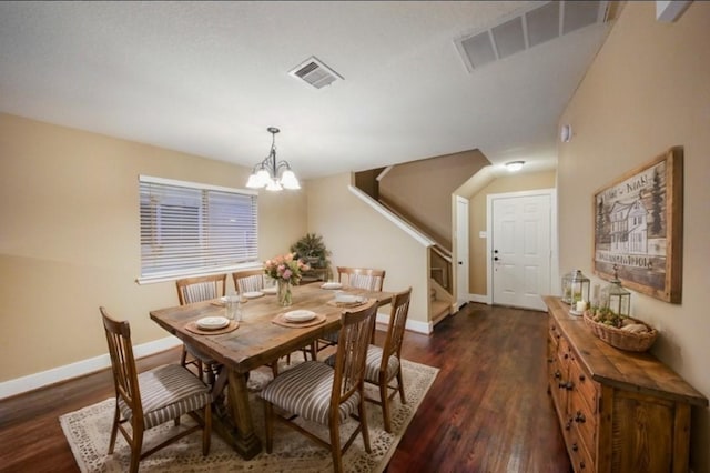 dining space featuring dark wood-type flooring and an inviting chandelier