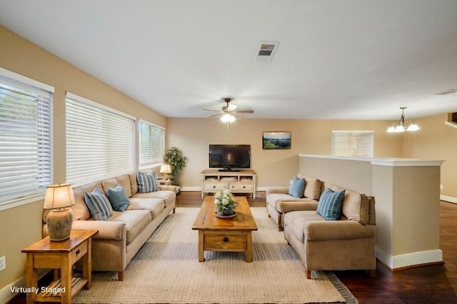 living room with wood-type flooring, ceiling fan with notable chandelier, and plenty of natural light