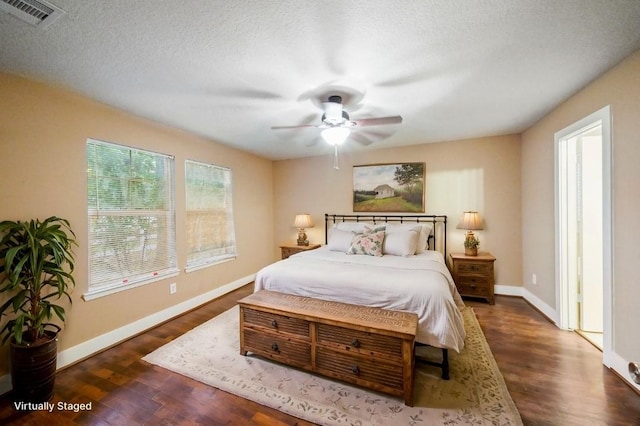 bedroom featuring ceiling fan, dark hardwood / wood-style floors, and a textured ceiling