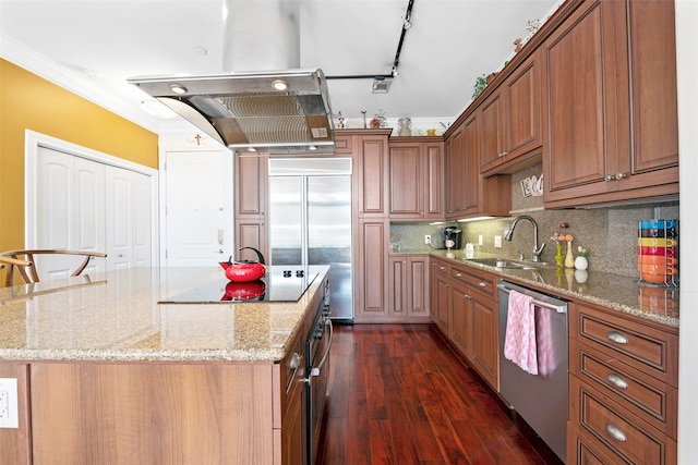 kitchen with light stone counters, a center island, stainless steel appliances, dark wood-type flooring, and crown molding