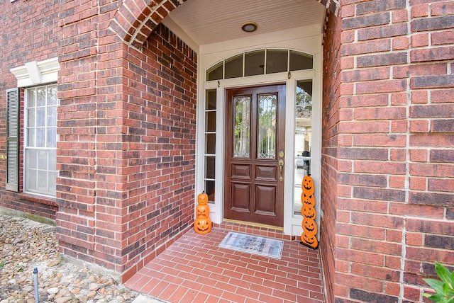 view of exterior entry featuring brick siding