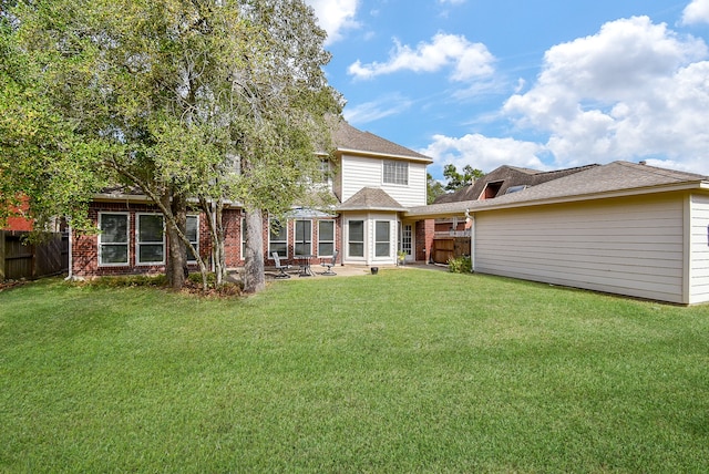 back of house with a yard and a patio