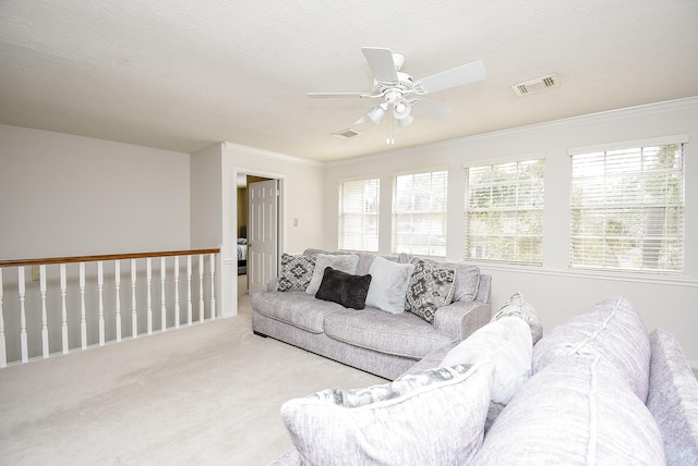 living room with light carpet, a wealth of natural light, visible vents, and crown molding