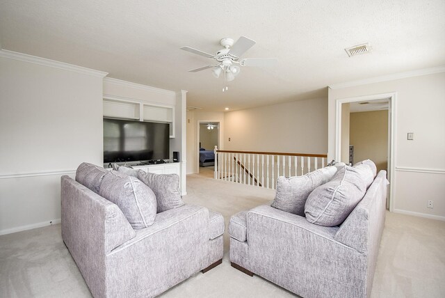 carpeted living room with ceiling fan, ornamental molding, and a textured ceiling