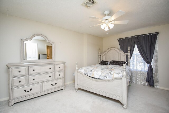 carpeted bedroom featuring a textured ceiling and ceiling fan