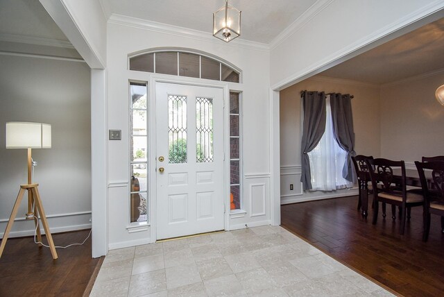 foyer entrance featuring crown molding and light wood-type flooring