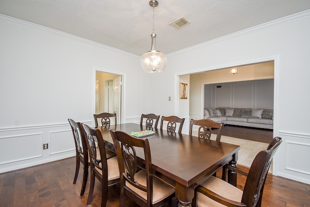 dining room featuring crown molding, a textured ceiling, and dark wood-type flooring