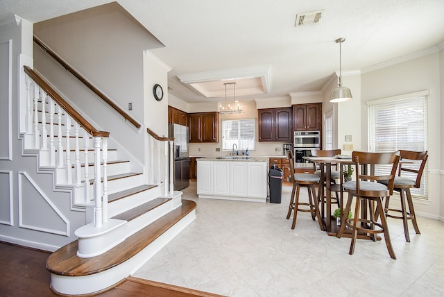 dining space featuring ornamental molding, sink, and an inviting chandelier