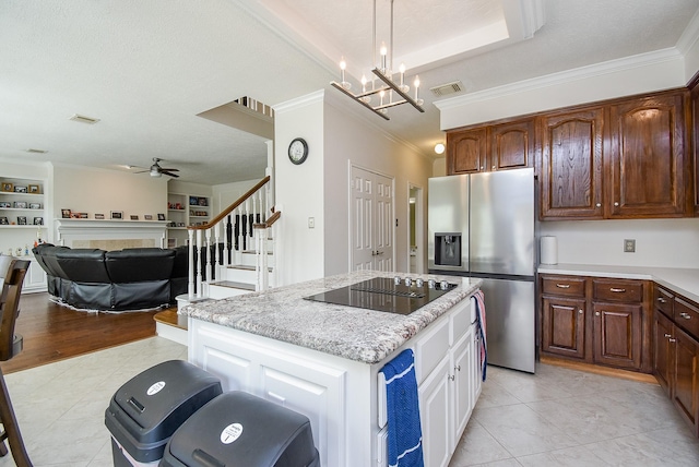 kitchen featuring black electric stovetop, a fireplace, a kitchen island, visible vents, and stainless steel refrigerator with ice dispenser