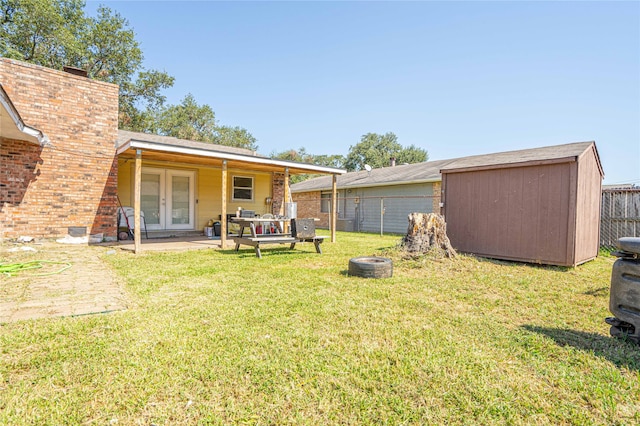 view of yard featuring a patio area, french doors, and a storage unit