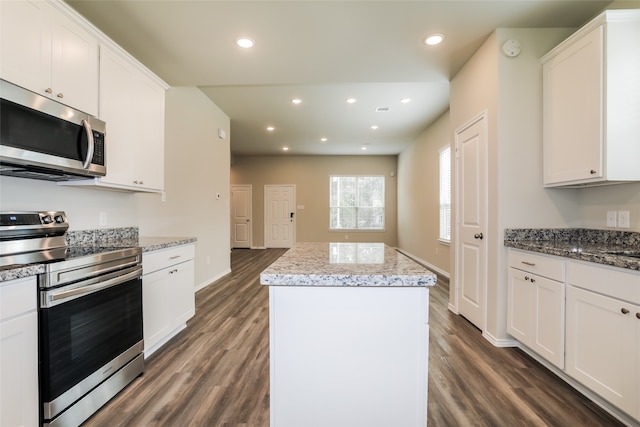 kitchen featuring dark hardwood / wood-style floors, appliances with stainless steel finishes, a kitchen island, and white cabinetry