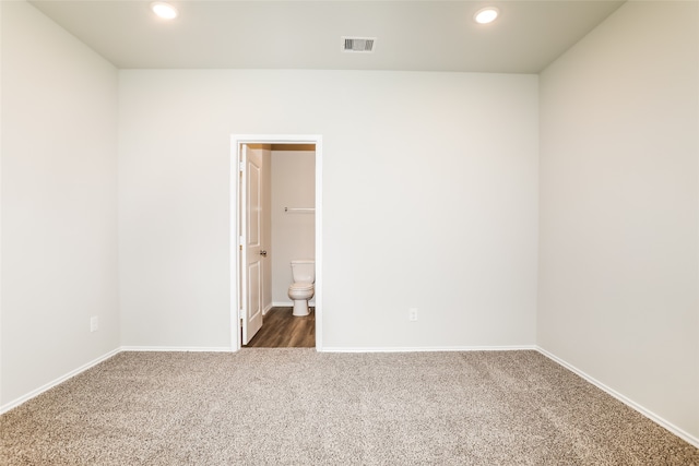 spare room featuring dark colored carpet