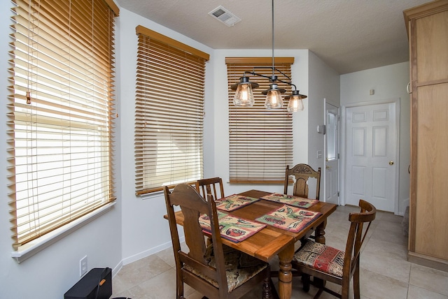 tiled dining area featuring plenty of natural light and a textured ceiling