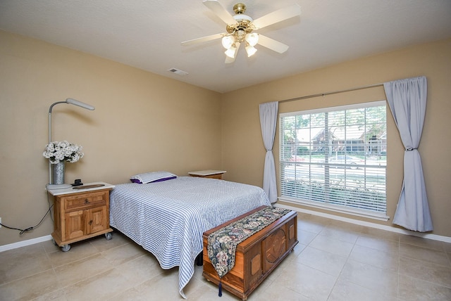 tiled bedroom featuring ceiling fan