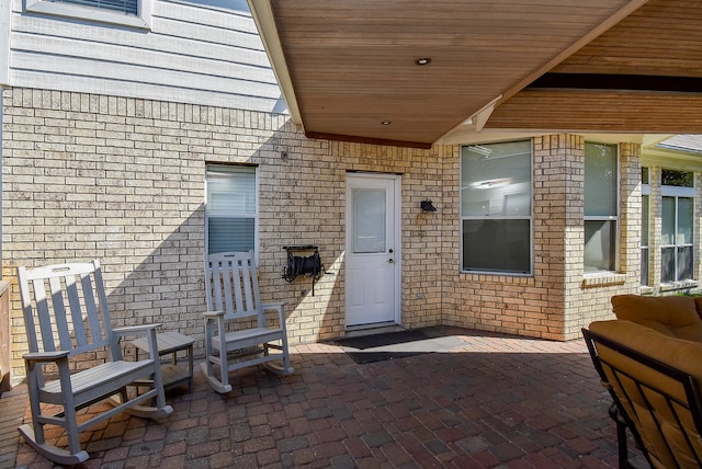 view of exterior entry featuring a patio area