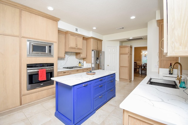 kitchen featuring light stone countertops, sink, light brown cabinets, a kitchen island, and appliances with stainless steel finishes