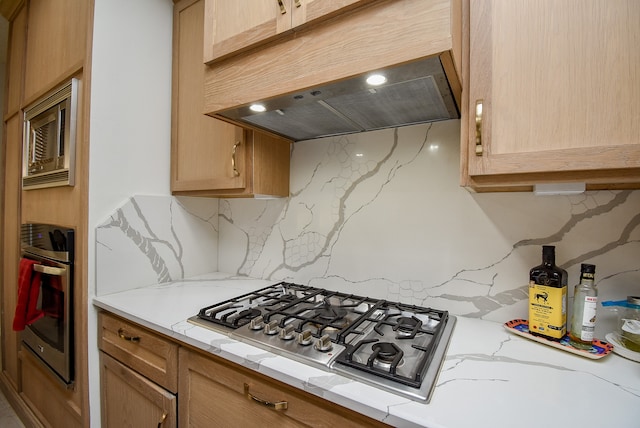 kitchen featuring tasteful backsplash, stainless steel appliances, and extractor fan