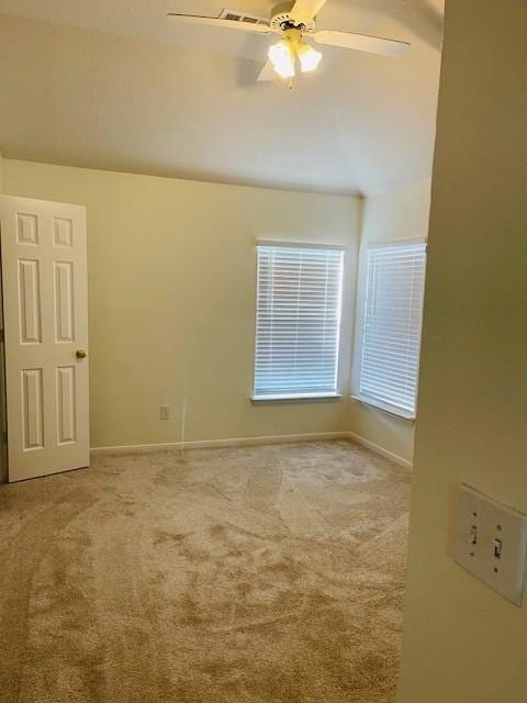 carpeted empty room featuring vaulted ceiling and ceiling fan