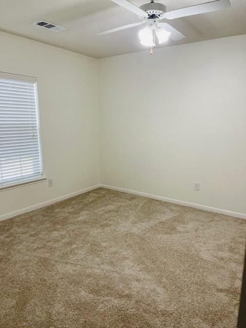 carpeted spare room with ceiling fan