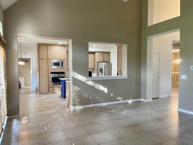 unfurnished living room with high vaulted ceiling and light tile patterned floors