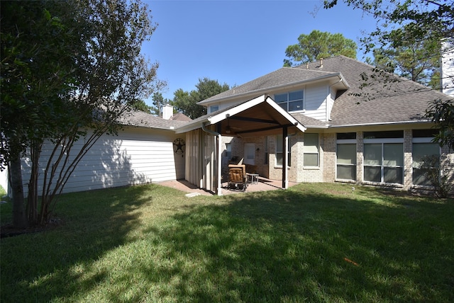 rear view of property with a patio, ceiling fan, and a lawn