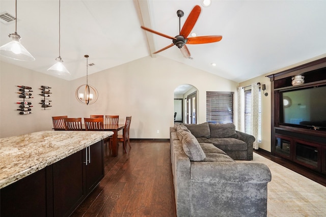 living room featuring ceiling fan with notable chandelier, lofted ceiling with beams, and dark wood-type flooring