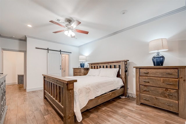 bedroom with ceiling fan, ornamental molding, light hardwood / wood-style floors, and a barn door